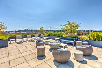 A roof terrace with chairs and tables overlooking a city